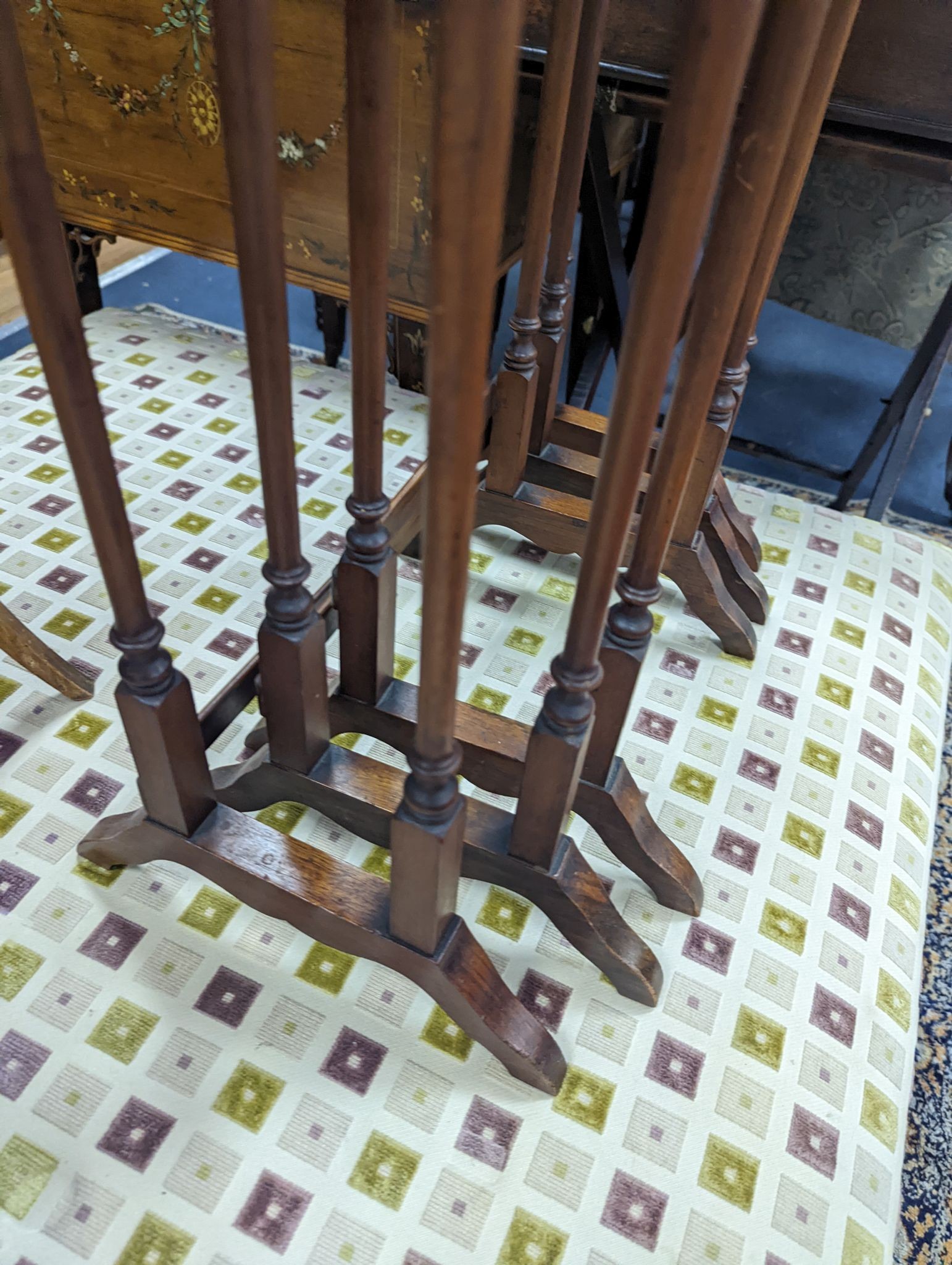 A nest of three oval and circular burr and simulated walnut tea tables, width 55cm, depth 37cm, height 60cm